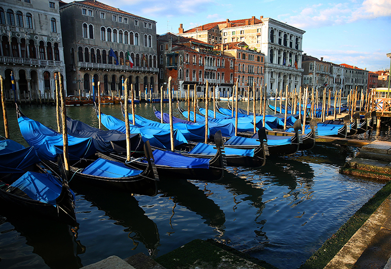 Gondolas sit along the Grand Canal in Venice, Italy.  Venice, the capital of northern Italy’s Veneto region, is built on more than 100 small islands in a lagoon in the Adriatic Sea. It has no roads, just canals – including the Grand Canal thoroughfare – lined with Renaissance and Gothic palaces.